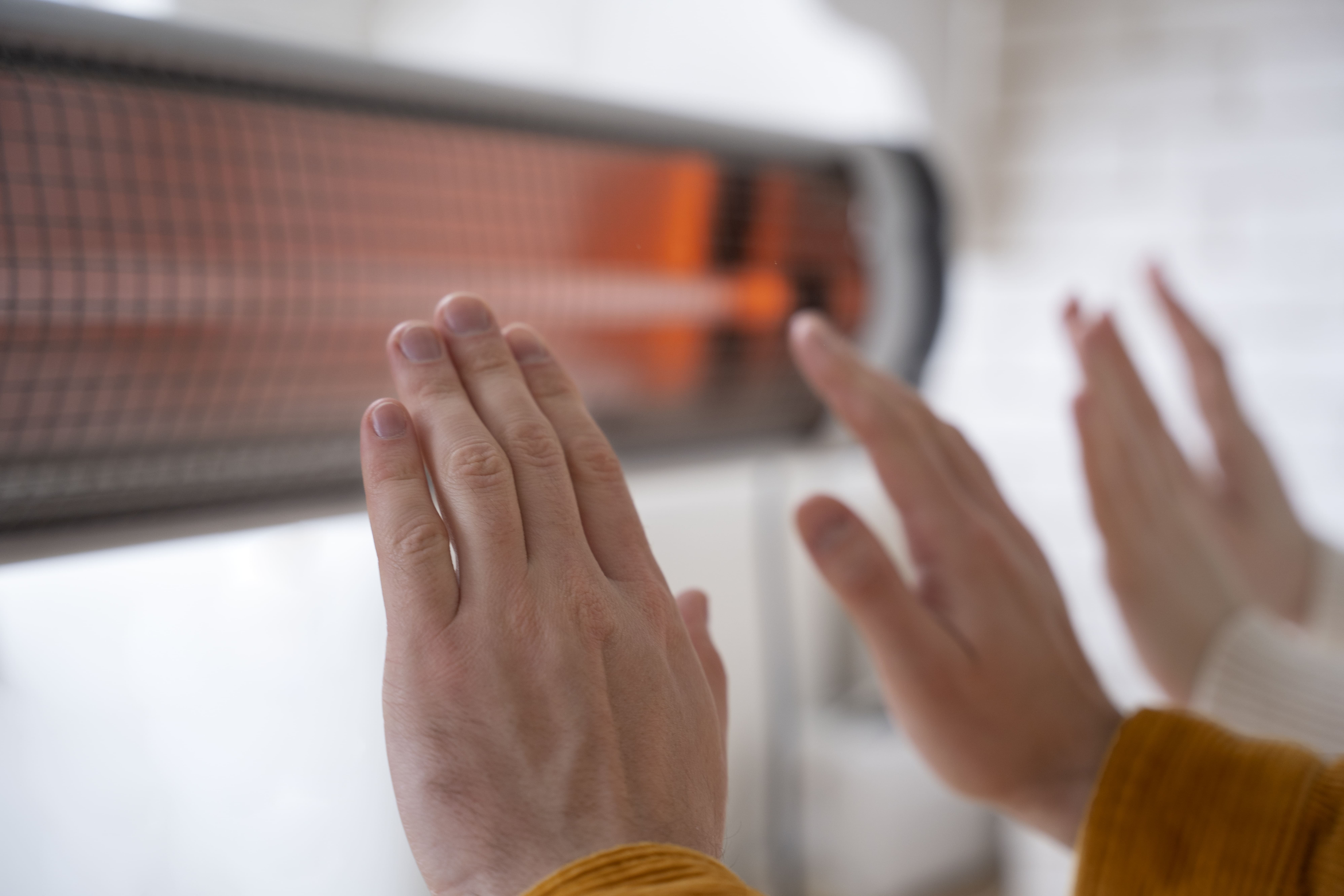 Cómo usar gas LP para calentar casa  - cerrar gente calentando manos cerca calentador 1 -